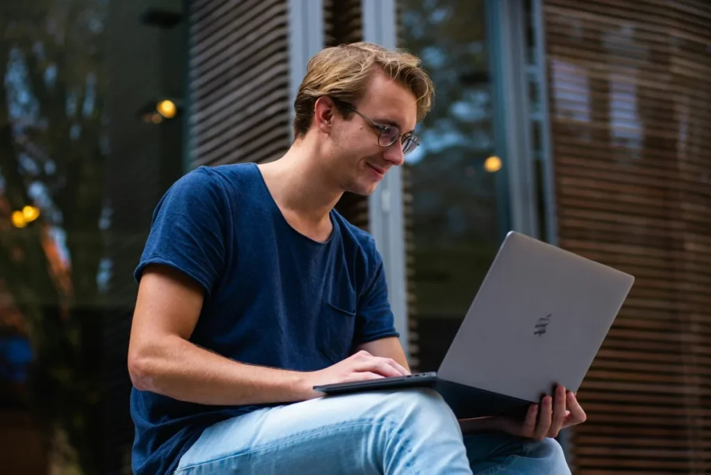 Remote worker sitting outside and working on a laptop