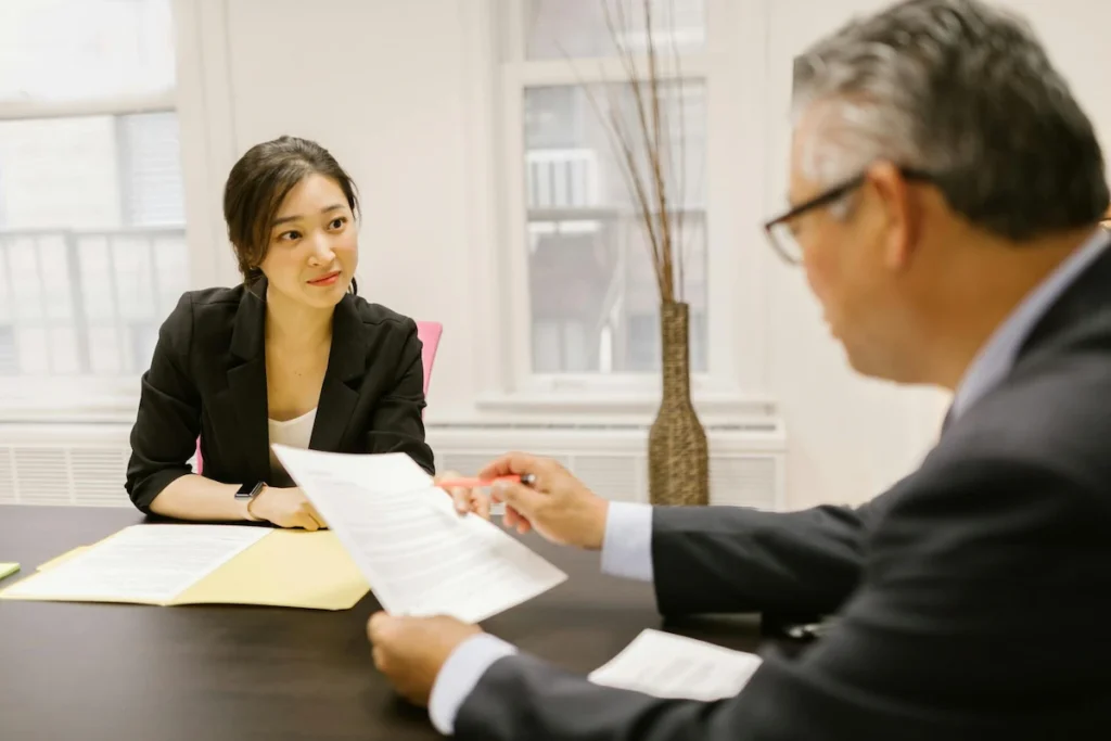 Professional advisor discussing BOI eligibility paperwork with a client in a Thailand business office.