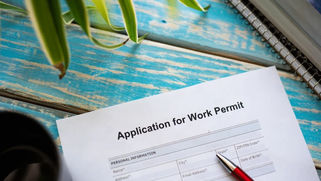 Application for Thailand work permit form with pen on a blue wooden table