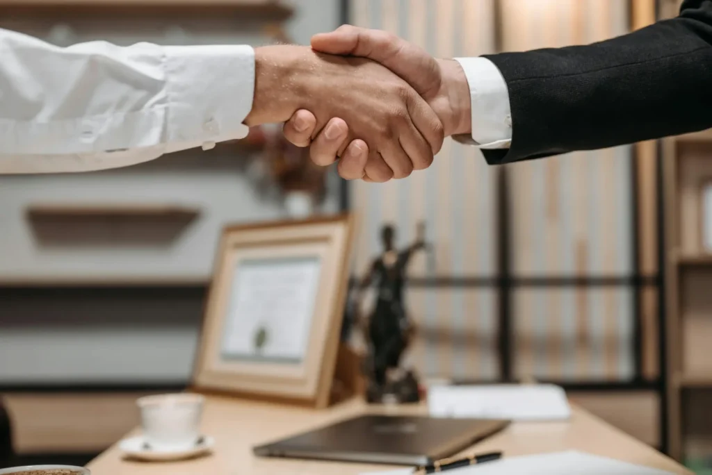 Close-up of two professionals shaking hands in a law office at Siam Visa & Business Law