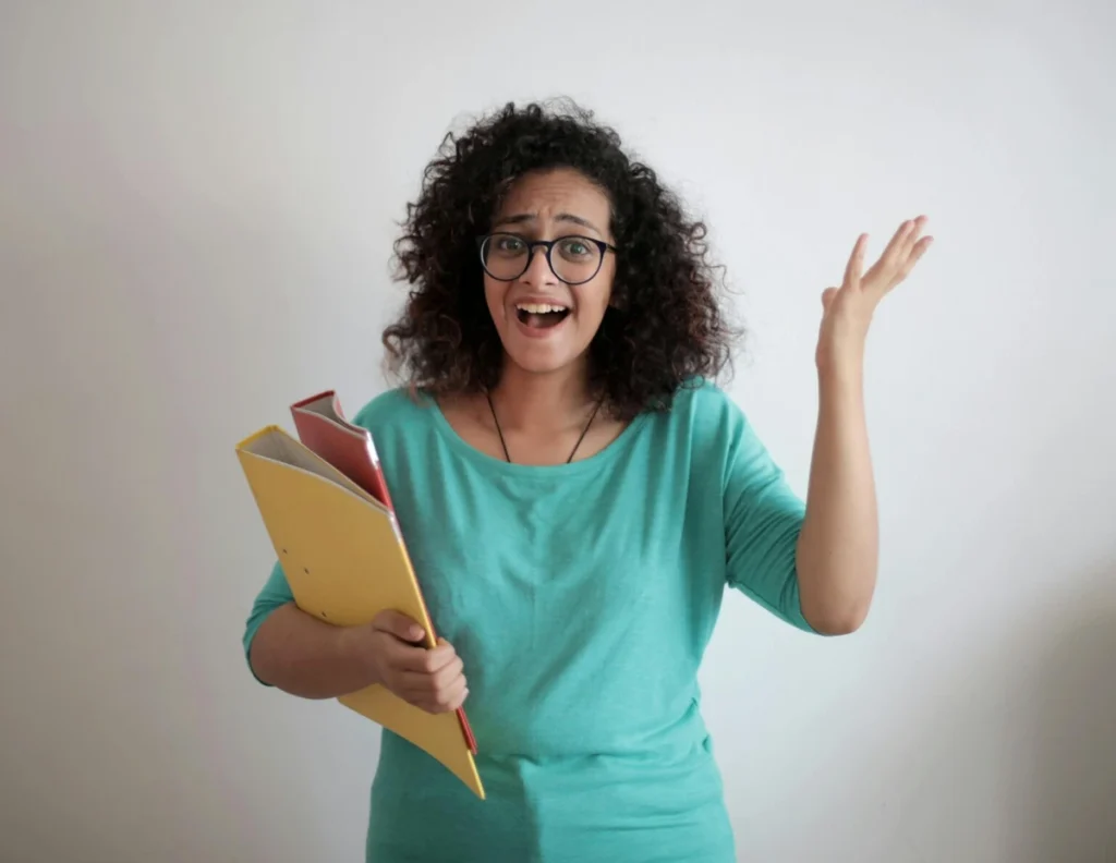 Young woman holding folders and looking confused about complex paperwork